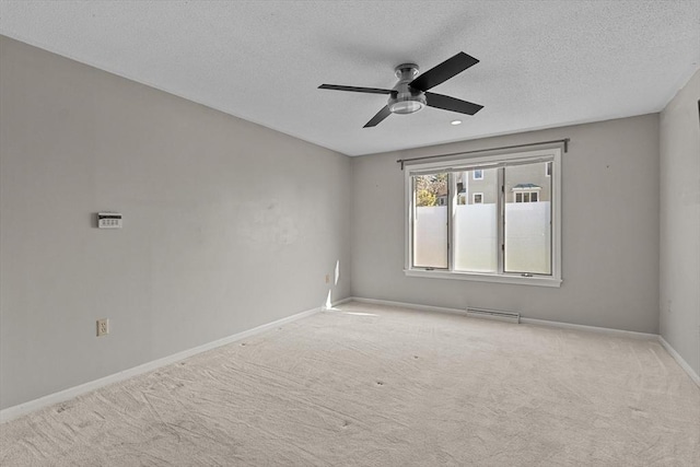 carpeted spare room featuring visible vents, a ceiling fan, a textured ceiling, and baseboards