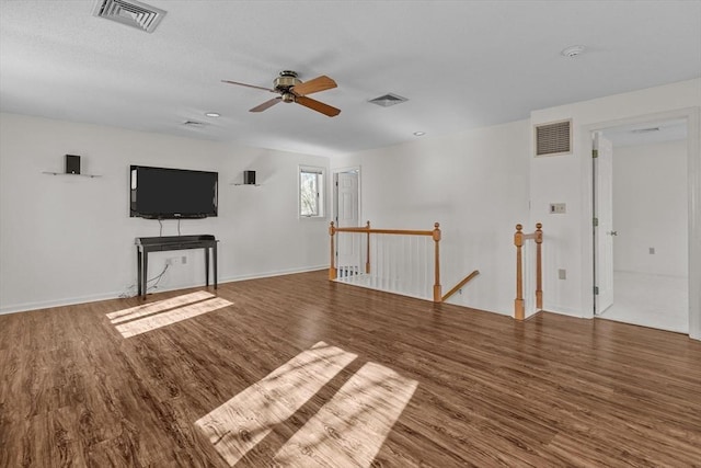 unfurnished living room featuring baseboards, ceiling fan, visible vents, and wood finished floors