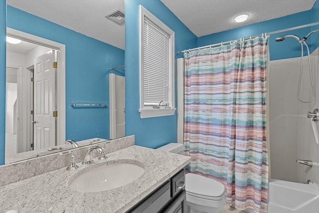 bathroom with a textured ceiling, visible vents, shower / tub combo, vanity, and toilet
