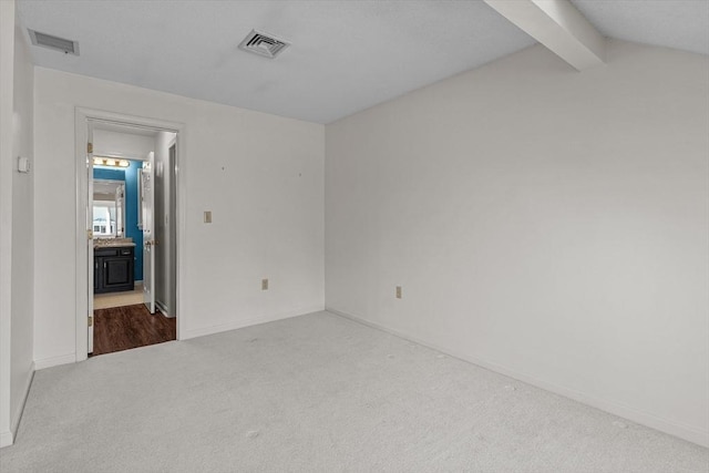 spare room with baseboards, visible vents, and carpet