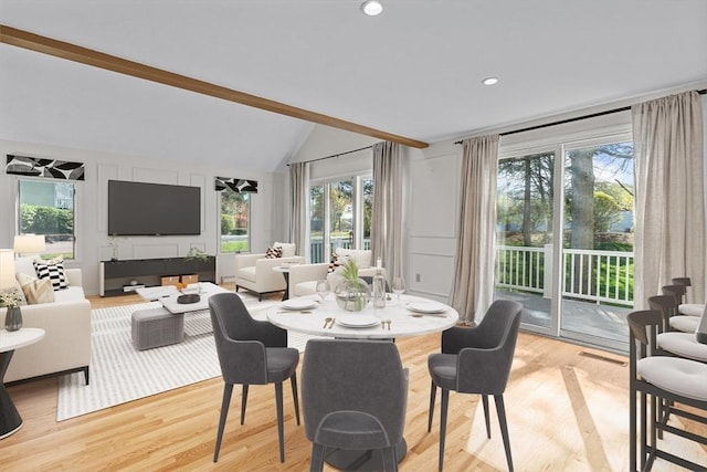 dining area featuring a healthy amount of sunlight, lofted ceiling with beams, light wood finished floors, and visible vents