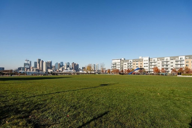 view of community featuring a view of city and a lawn