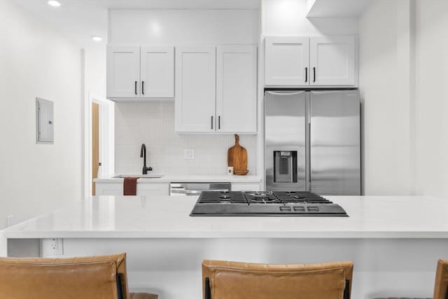 kitchen featuring stainless steel appliances, tasteful backsplash, a breakfast bar area, and a sink