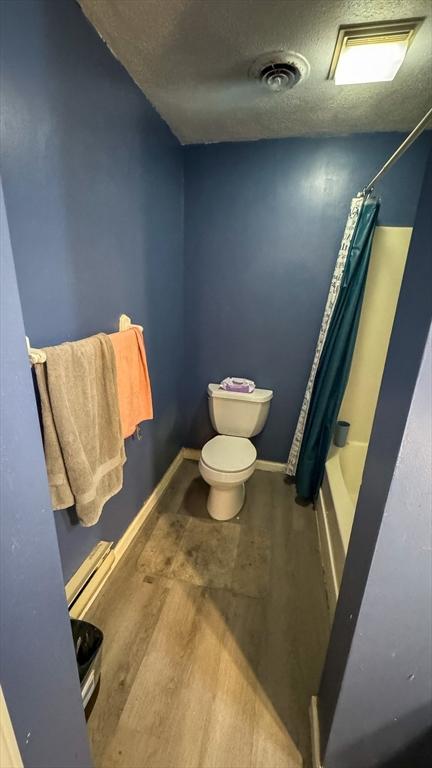 2 Altavesta Cir Unit A, Woburn, MA 01801 - full bath with toilet, a textured ceiling, wood finished floors, shower / bath combo with shower curtain, and baseboards