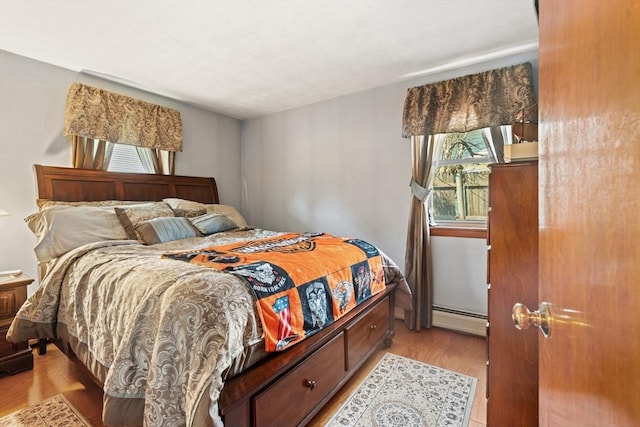 bedroom featuring light wood-style flooring and baseboard heating