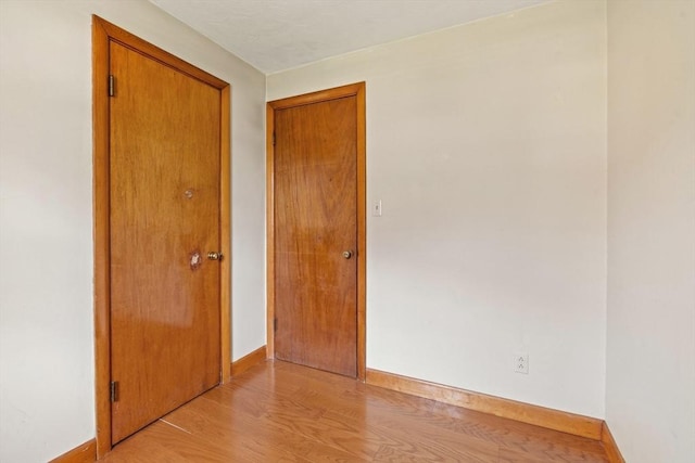 empty room with baseboards and light wood-style flooring