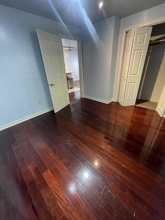 unfurnished room with dark hardwood / wood-style flooring