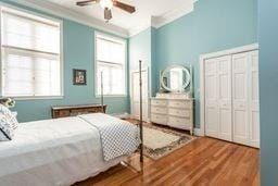 bedroom featuring ornamental molding, ceiling fan, and wood finished floors