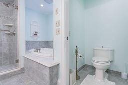 bathroom with a shower stall, tile patterned flooring, a bath, and toilet