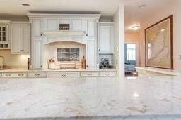 interior space featuring glass insert cabinets and light stone counters