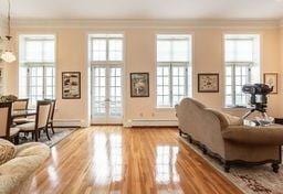 living area with baseboards, ornamental molding, french doors, a baseboard radiator, and wood finished floors