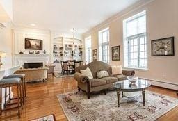 living room with ornamental molding, a wealth of natural light, wood finished floors, and a fireplace