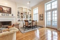 dining room featuring built in features, a fireplace, crown molding, wood finished floors, and french doors