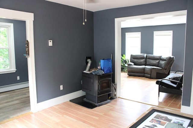 34-36 Glenallen St, Winchendon, MA 01475 - living room featuring a wood stove, wood finished floors, and a baseboard heating unit