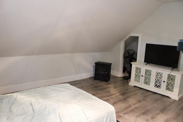 34-36 Glenallen St, Winchendon, MA 01475 - bedroom featuring a wood stove, vaulted ceiling, and wood finished floors