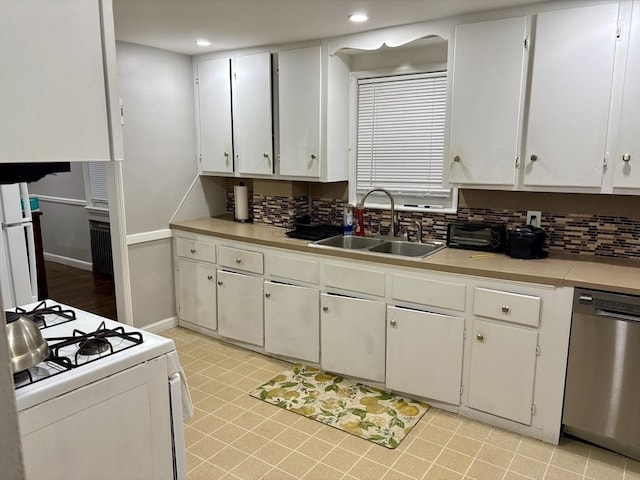 kitchen featuring white appliances, a sink, light countertops, white cabinets, and tasteful backsplash