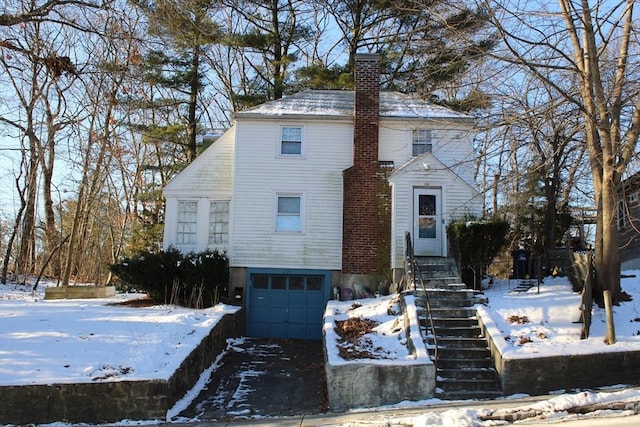 view of front facade with a chimney and a garage