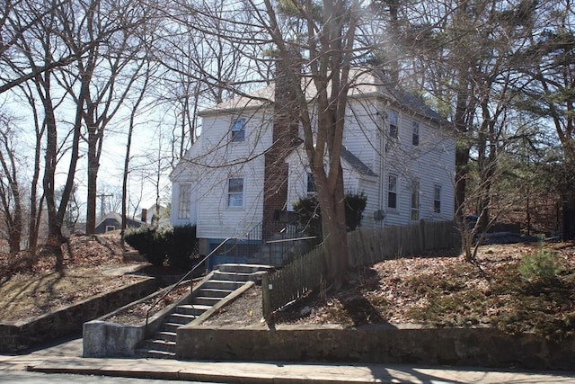 view of side of property with stairway and fence