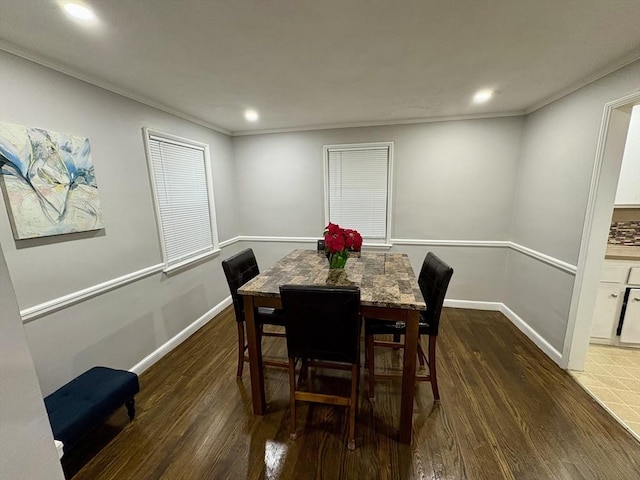 dining space with dark wood-type flooring and crown molding