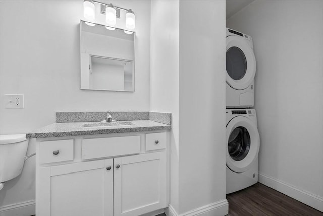 693 Western Ave Unit 404, Lynn, MA 01905 - laundry room featuring stacked washer and clothes dryer, baseboards, and dark wood-type flooring