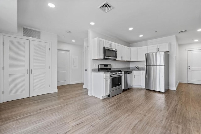 693 Western Ave Unit 404, Lynn, MA 01905 - kitchen featuring stainless steel appliances, baseboards, recessed lighting, white cabinetry, and light wood finished floors