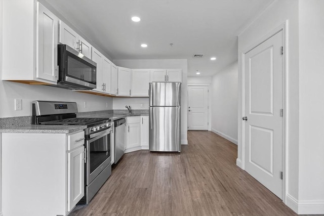 693 Western Ave Unit 404, Lynn, MA 01905 - kitchen featuring stainless steel appliances, wood finished floors, white cabinets, and recessed lighting