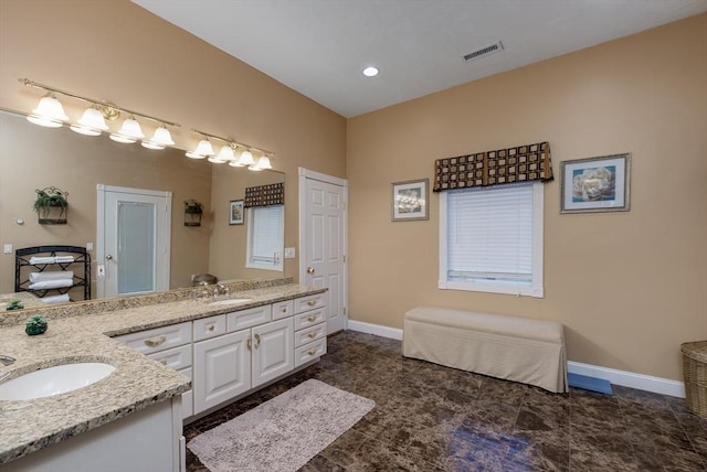 full bathroom featuring double vanity, baseboards, visible vents, and a sink