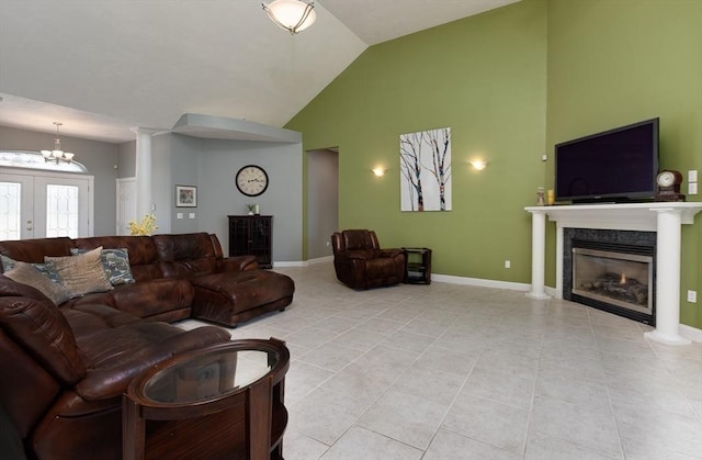 living room featuring a fireplace, light tile patterned floors, baseboards, high vaulted ceiling, and a notable chandelier