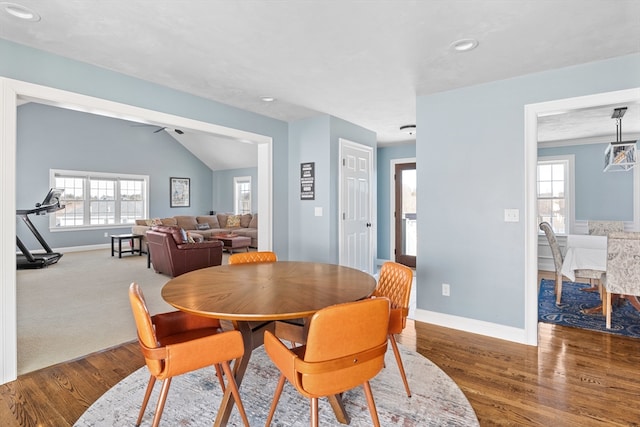 dining room with vaulted ceiling, wood finished floors, and baseboards