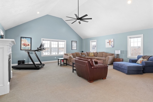 carpeted living area with baseboards, a fireplace, high vaulted ceiling, and a ceiling fan