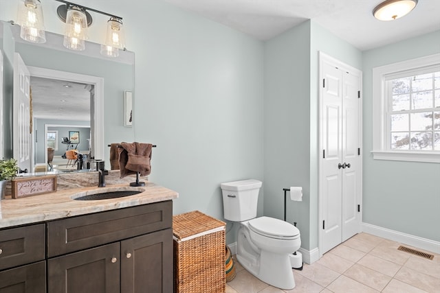 bathroom featuring tile patterned flooring, toilet, vanity, visible vents, and a closet