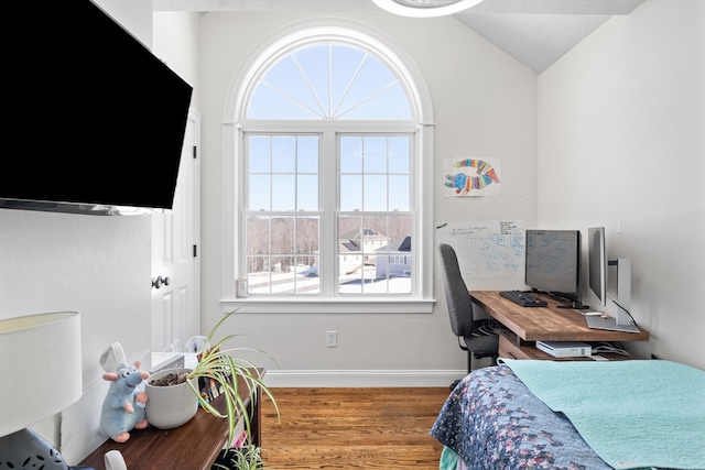 bedroom featuring lofted ceiling, wood finished floors, and baseboards