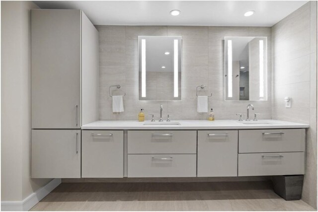 bathroom with vanity and tile walls