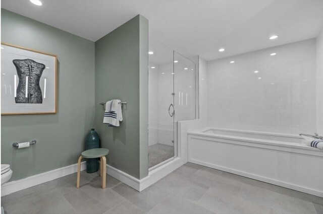 bathroom featuring tile patterned flooring, toilet, and shower with separate bathtub