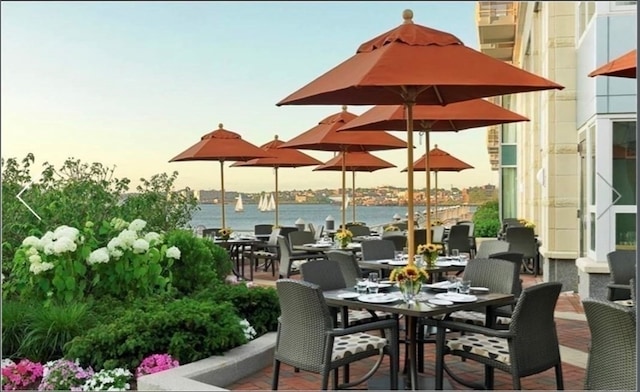 patio terrace at dusk featuring a water view