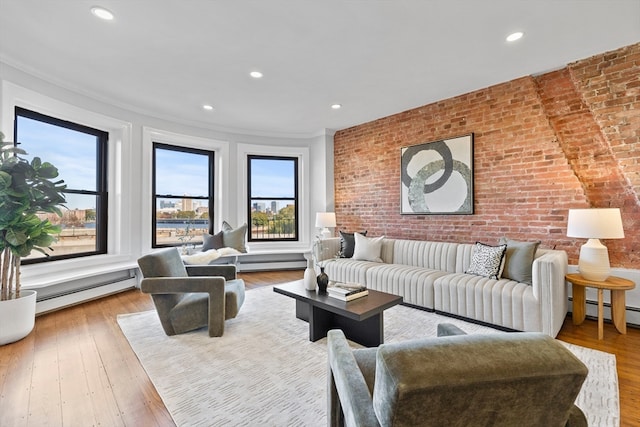 living room with a wealth of natural light, brick wall, and light hardwood / wood-style floors