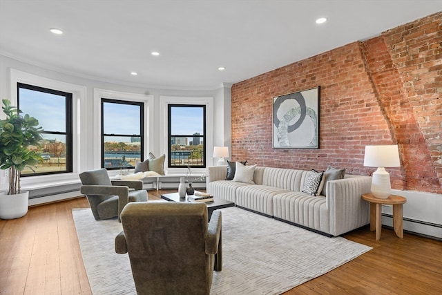 living room with brick wall, crown molding, and light hardwood / wood-style flooring