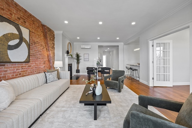 living room with an AC wall unit, brick wall, crown molding, and light wood-type flooring