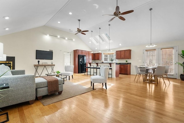 living room featuring high vaulted ceiling, recessed lighting, ceiling fan, and light wood-style flooring