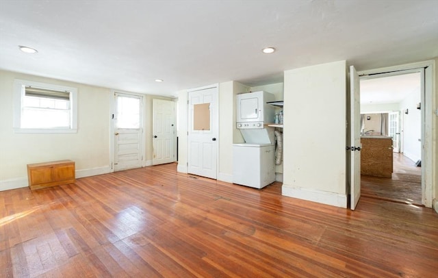 interior space featuring hardwood / wood-style flooring and stacked washer / dryer