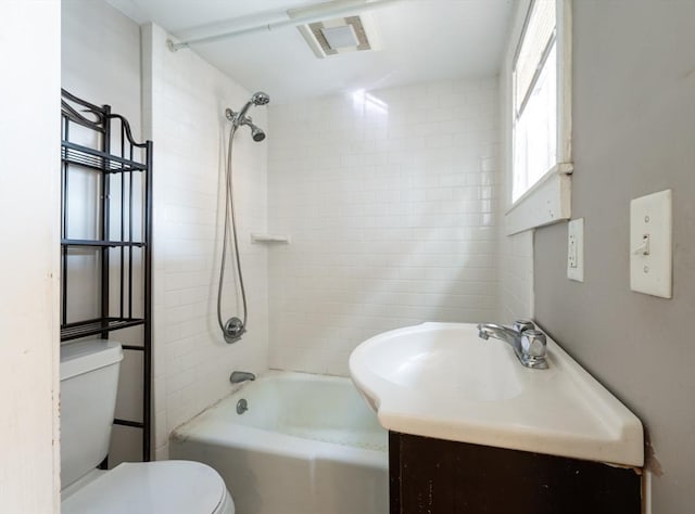 full bathroom with vanity, tiled shower / bath combo, and toilet