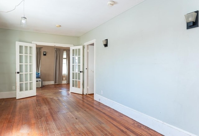 unfurnished room featuring french doors and hardwood / wood-style floors