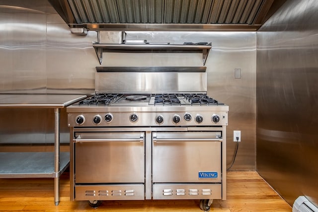 kitchen featuring luxury range, light hardwood / wood-style floors, and a baseboard radiator