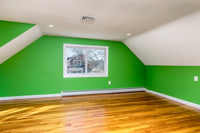 bonus room with vaulted ceiling, a baseboard heating unit, and light hardwood / wood-style flooring