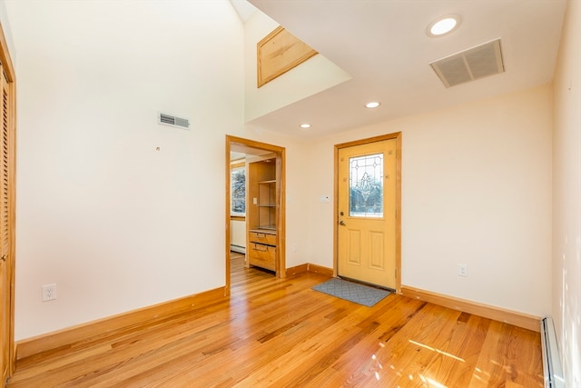 foyer with baseboard heating and light hardwood / wood-style flooring