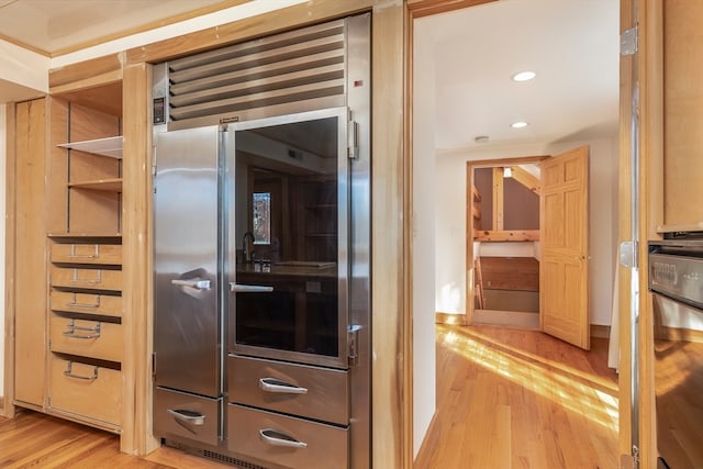 interior space featuring light brown cabinets, stainless steel built in refrigerator, and light wood-type flooring