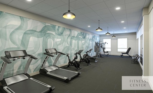 gym featuring baseboards, a paneled ceiling, and recessed lighting