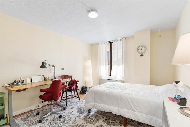 bedroom featuring hardwood / wood-style flooring and a textured ceiling