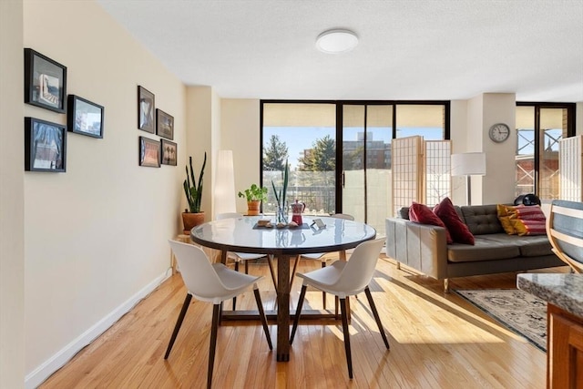 dining area featuring expansive windows and light wood-type flooring