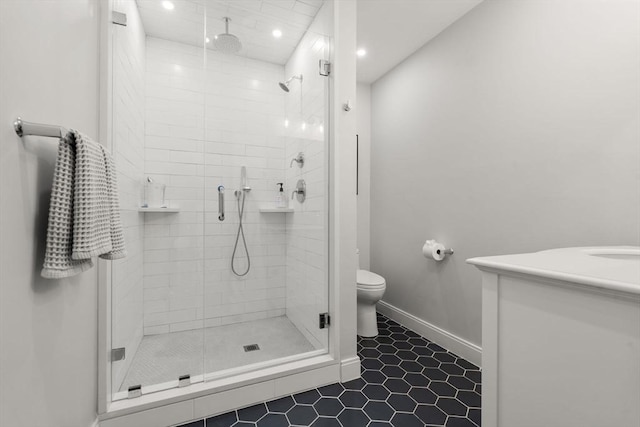 bathroom with an enclosed shower, vanity, tile patterned floors, and toilet